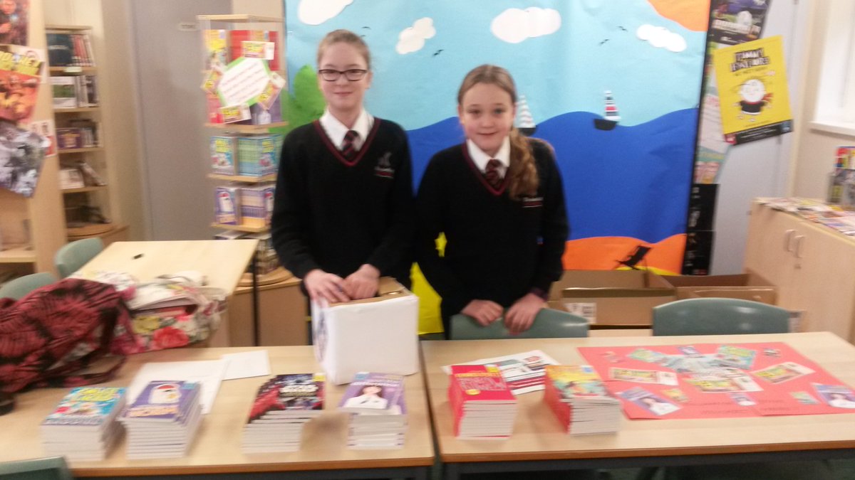 Library helpers ready for action with the piles of FREE books #worldbookday