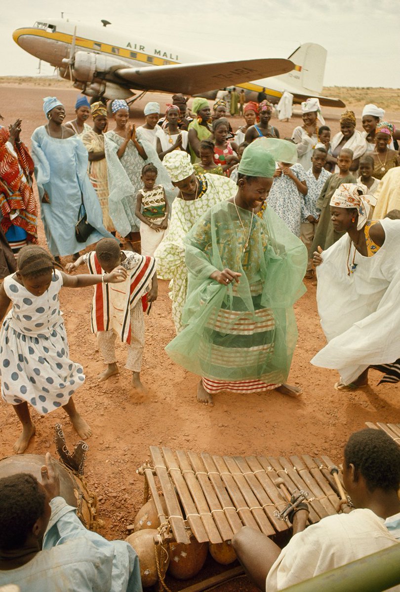Goodwill/farewell celebrations to send off a family member embarking on a flight to Paris. Mopti, Mali, 1966.