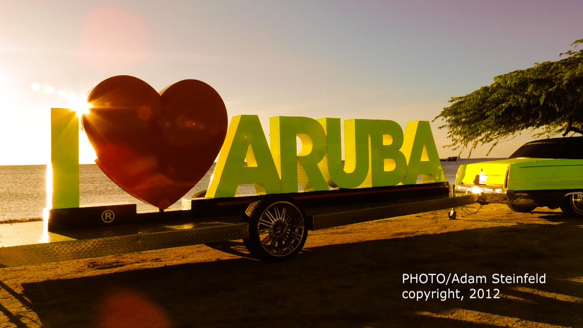sunset in Aruba, movable, I heart Aruba sign, pulled by old Cadillac, in Malmok area.