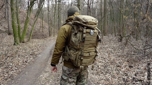 Боец с красным рюкзаком. Рюкзак выживальщика. Рюкзак для похода. Боец с рейдовым рюкзаком. Каремат на рюкзаке.