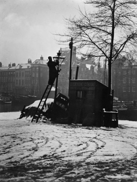 Een lantaarn wordt schoongemaakt aan de Wolfshoek bij de Leuvehaven, 1910. Foto: H. Berssenbrugge. <a href="/stadsarchief010/">Stadsarchief 010</a>