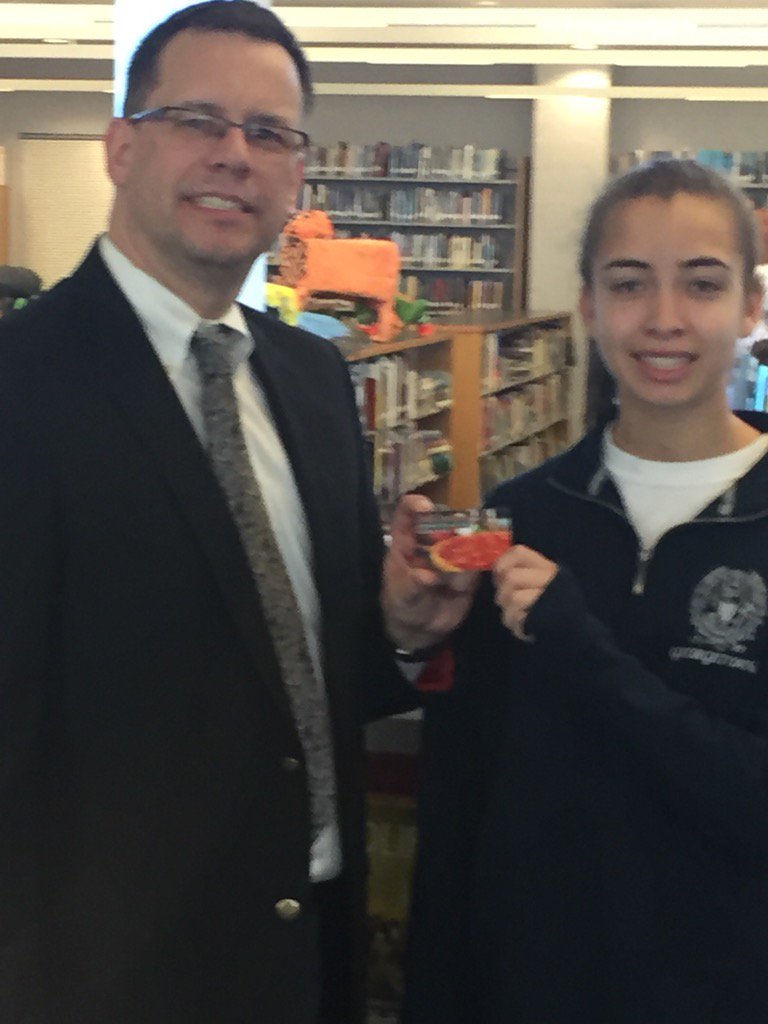 Dr. John Doll presenting Deli Italiano gift certificate to Artist of the Month Cameron McClesky.