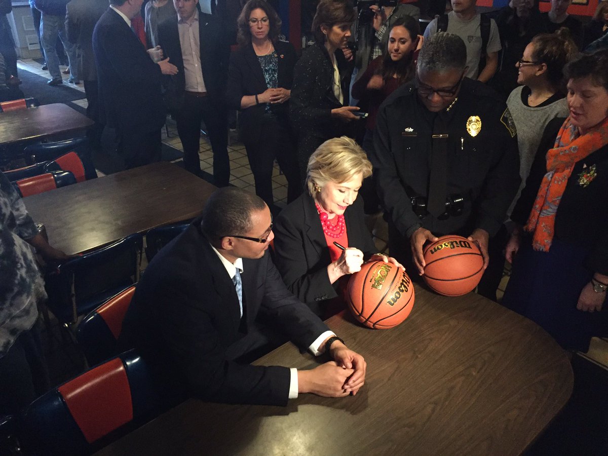 merica's tweet image. Hillary Clinton signs two basketballs in Syracuse.