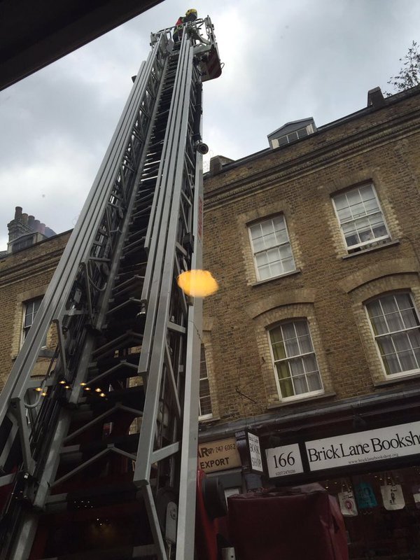 Crews at work using a turntable ladder to tackle the on-going fire in offices under refurbishment on #BrickLane.