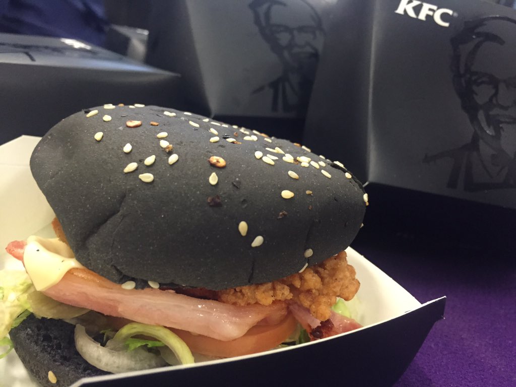 KIIS1065's tweet photo. It may not look like your typical burger, but the KFC #ZingerBlack is DELICIOUS. Intern Pete promises. #KIIS1065 https://t.co/kjsMQQN8YY