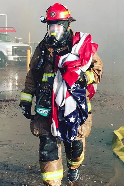 KTLA's tweet photo. Photo of firefighter saving American flag from burning building ignites wave of patriotism https://t.co/LXtYJgnfp8 https://t.co/XdsbWKuGb8