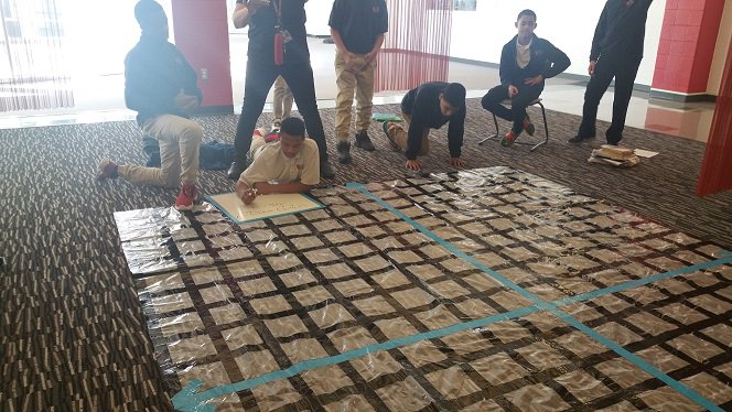 8th graders in Ms. Moss' class working in pairs to find the slope of a line on a life scale grid.