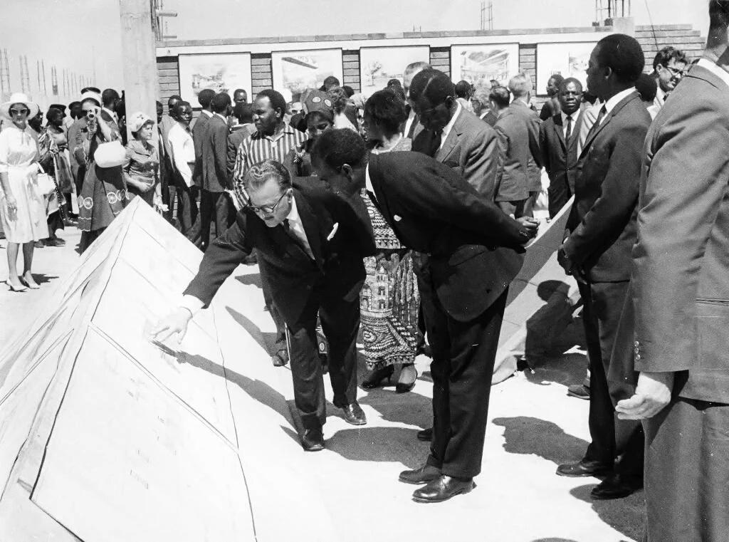 Zambia's 1st President, Dr. Kaunda, being briefed on the Lusaka airport construction, 1965. Named after him in 2010