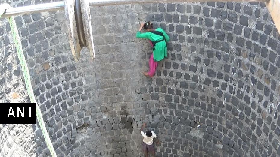ANI's tweet photo. MP:Children risk lives in a village in Dindori while climbing down an almost dried up well to get the remaning water https://t.co/U6jnzG3nam