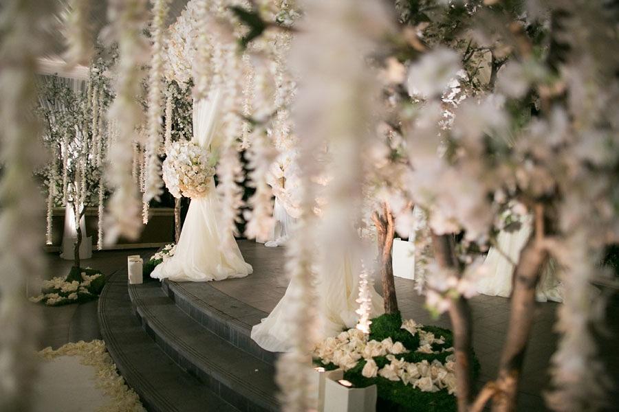 The ceremony was embellished with a canopy covered in soft ivory chiffon, floral bouquets, floral trees and orchid …