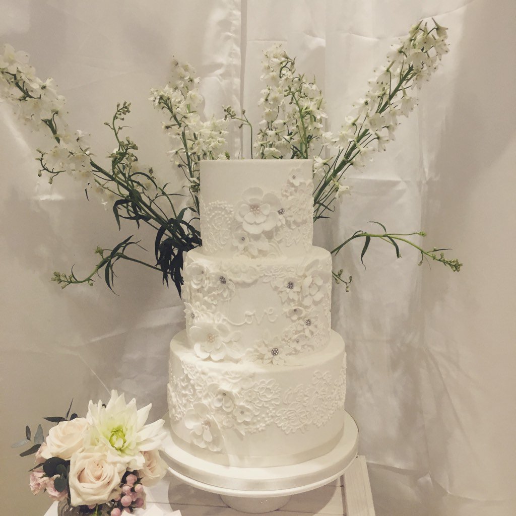 White lace lovely from this weekends wedding fair at the excel. Hand piped lace with appliqué flowers #weddingcake