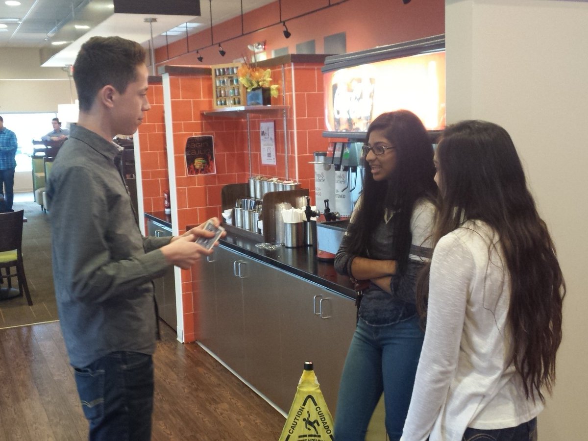 Marketing students selling, providing entertainment, and interacting at Tom and Eddies