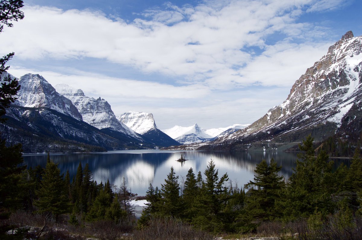 Interior's tweet photo. Snow-dusted peaks frame St. Mary Lake in this iconic view of @GlacierNPS Pic: Derek Bennington #FindYourPark https://t.co/8HWPyuc8fa