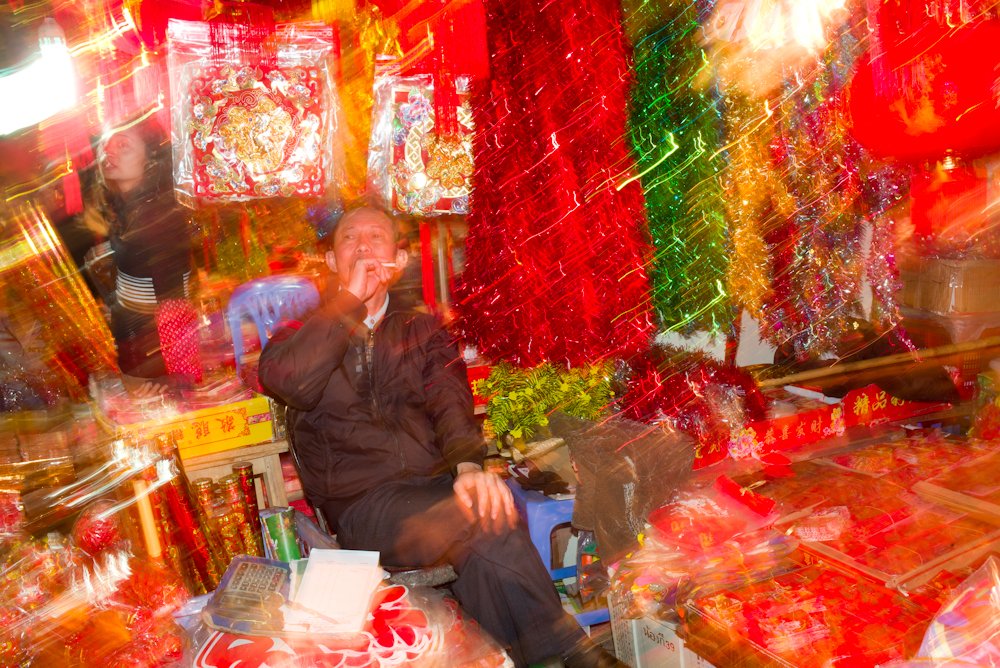 Years ago in Hanoi during Tet festival. Street food day and night. 1 sec exp  + flash fired on shutter close.