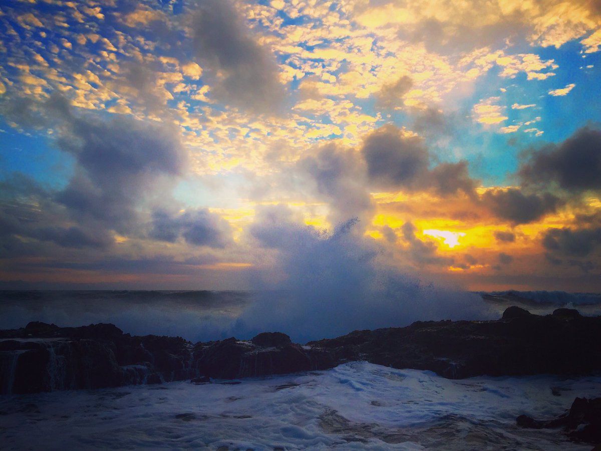 大浪击打礁石，飞起浪花和海雾连成一片。低层云挡住，沒有等到夕阳照到海浪上。