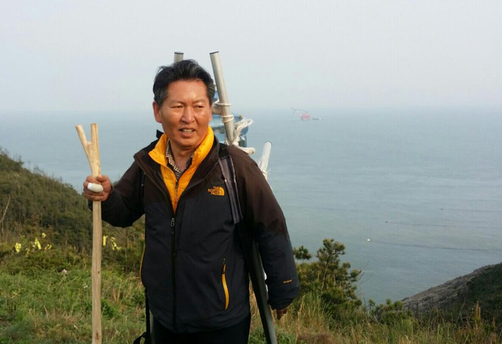 ssaribi's tweet photo. <동거차도에서 물지게꾼 정청랩니다.>제 뒷쪽 뿌연 바다안개 사이로 보이는 뻘건 물체가 세월호인양 바지선입니다. 이곳 산정상에서 유가족들이 텐트를 치고 망원경으로 감시중입니다. 감시 잘하라고 물배달 왔습니다. https://t.co/jdpoJjHU1z