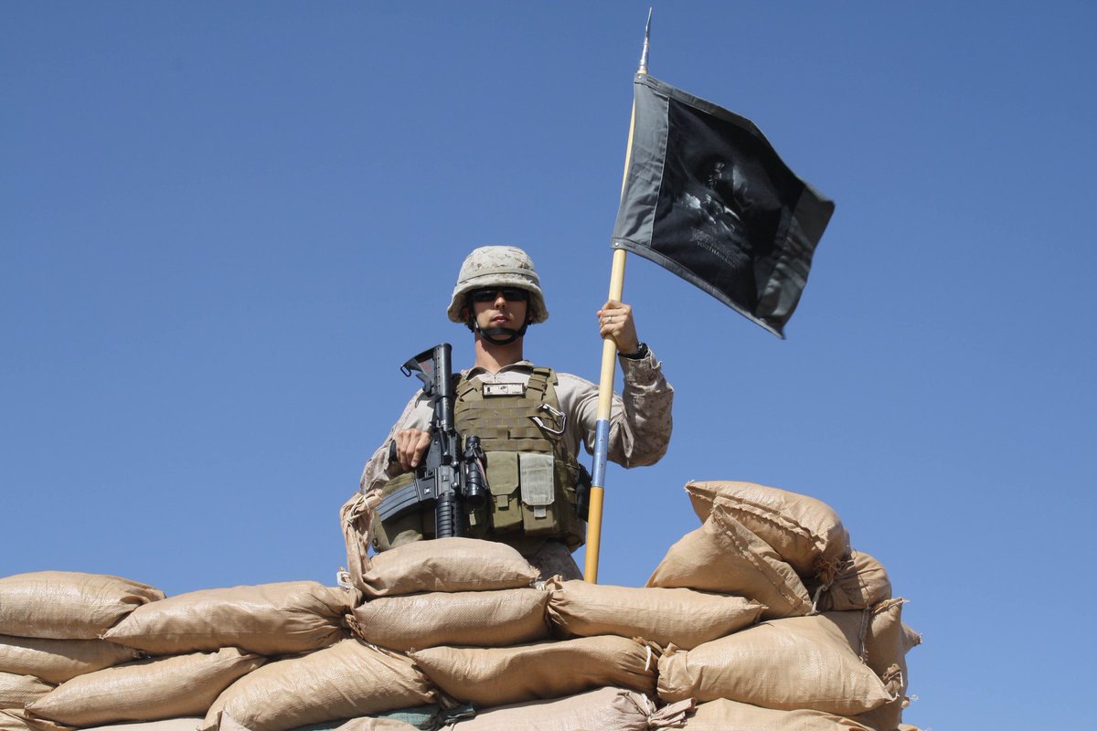 Megadeth's tweet photo. Captain Joe Masini with his Vic flag flying over the base in Afghanistan. Thank you Joe &amp; @USMC for keeping us safe! https://t.co/H9meW1OHE1