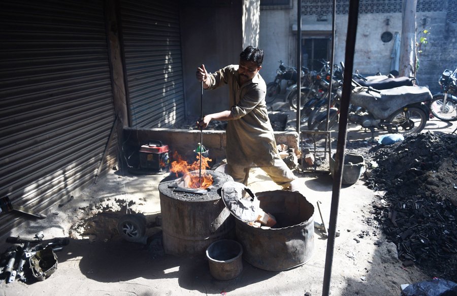 A Pakistani laborer works in an iron factory in Karachi on Saturday, on
