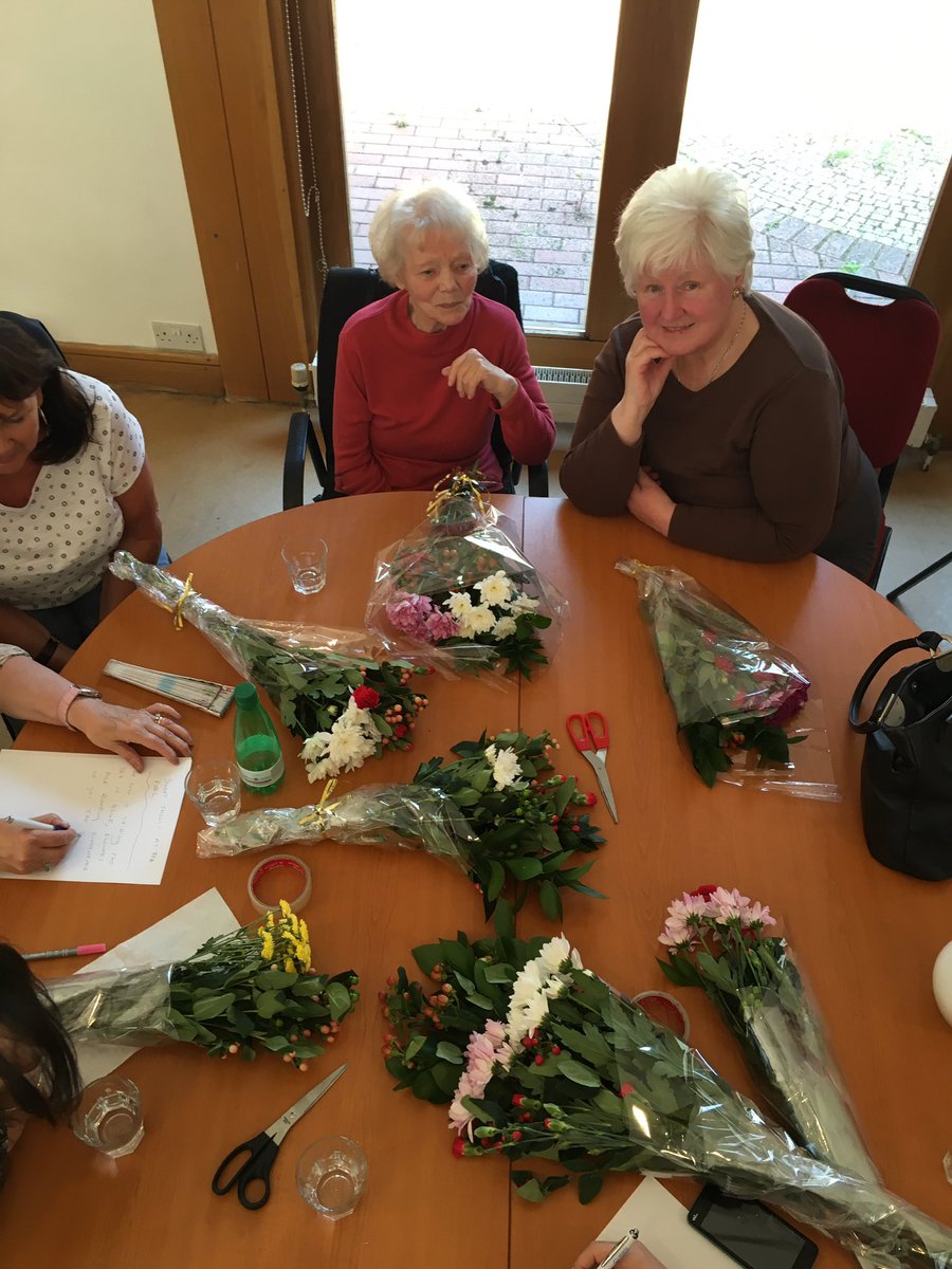 RootlessGarden's tweet image. Nan &amp;amp; Noreen, surrounded by flowers writing poems with their team mates.