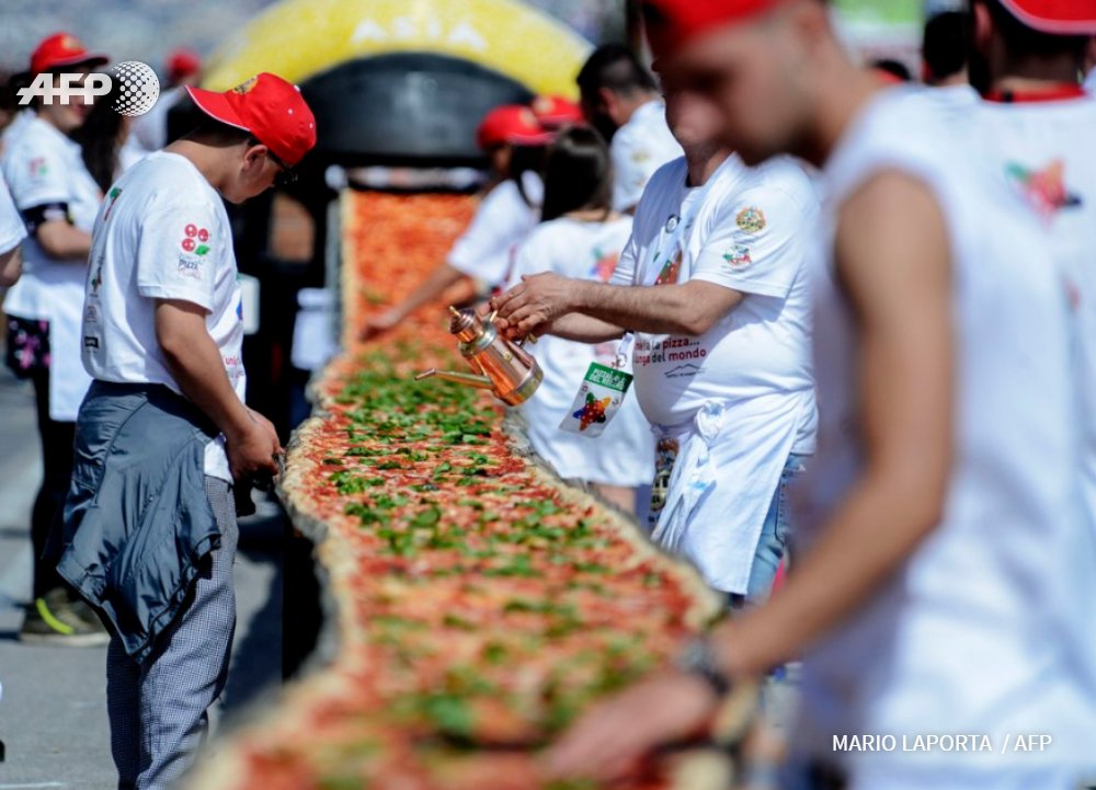 AFP's tweet photo. Neapolitan pizza makers attempt to break a #guinnessworldrecord using 1,600 kg of tomatoes, 2,000 kg of mozzarella.. https://t.co/bRlUzK1hzO