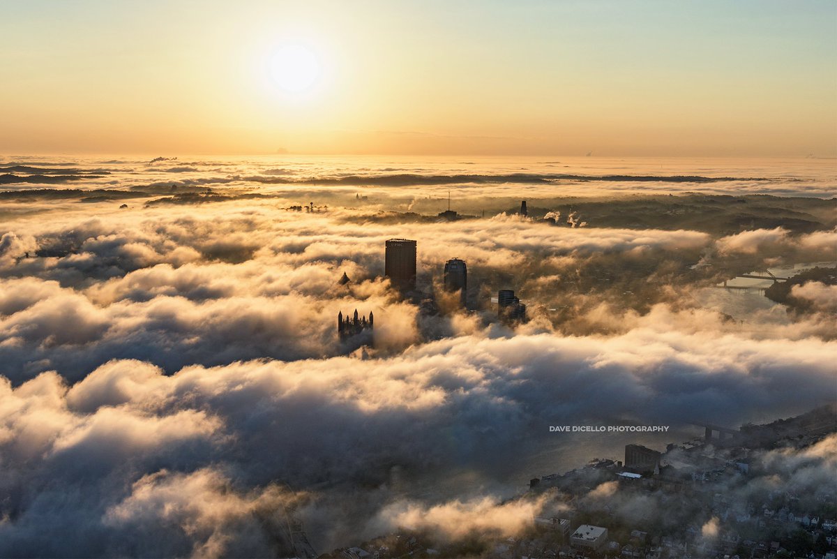 DaveDiCello's tweet photo. The #Pittsburgh skyline emerges from the fog this morning as the sun rises overhead, like something out of a dream https://t.co/J2LSGGJe5F