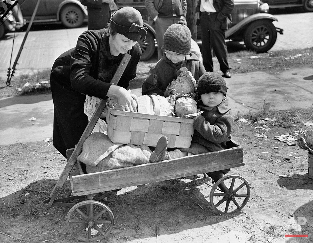 A mother and her children receive their allotment of potatoes, cabbage and butter at a Cleveland depot #OTD in 1938.