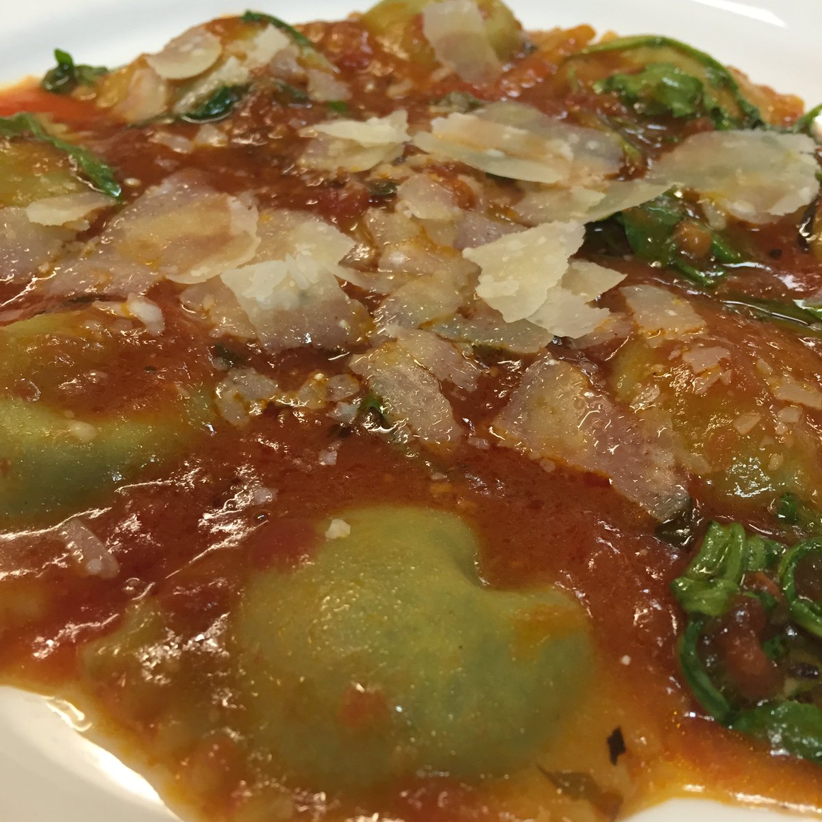 Homemade spinach &amp; ricotta ravioli is served in our classic tomato sauce.