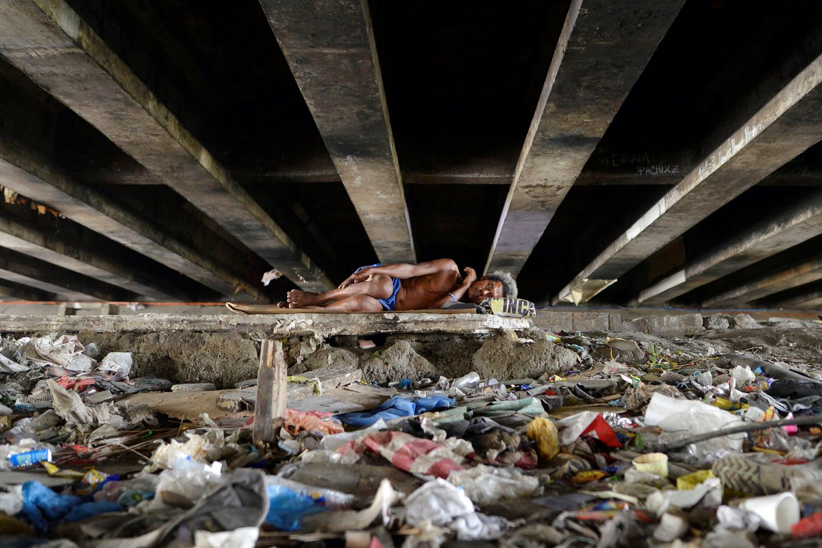 Geniustechw's tweet photo. A man sleeps amid rubbish under a bridge, Paranaque, Philippines.

We need much less than we think we need. https://t.co/EvVJUBcy7R