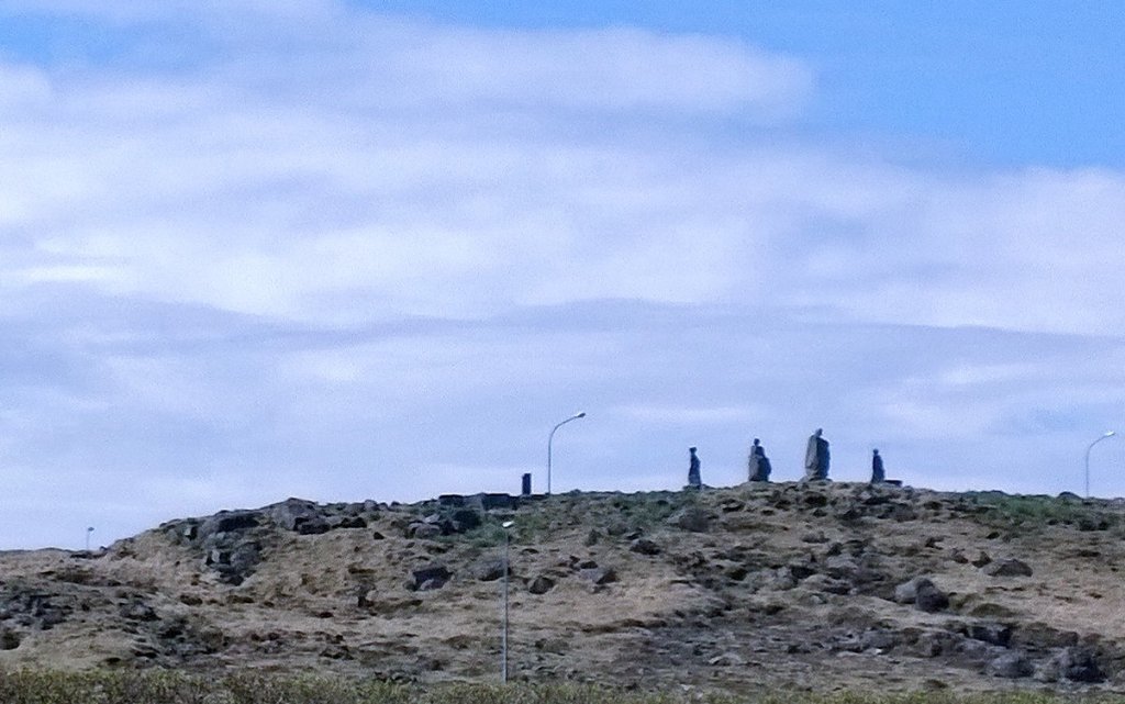 Rattify's tweet photo. Tall lava rock cairns top hillsides in Iceland, like distant cloaked figures. #miceland https://t.co/VnLHWMRypy
