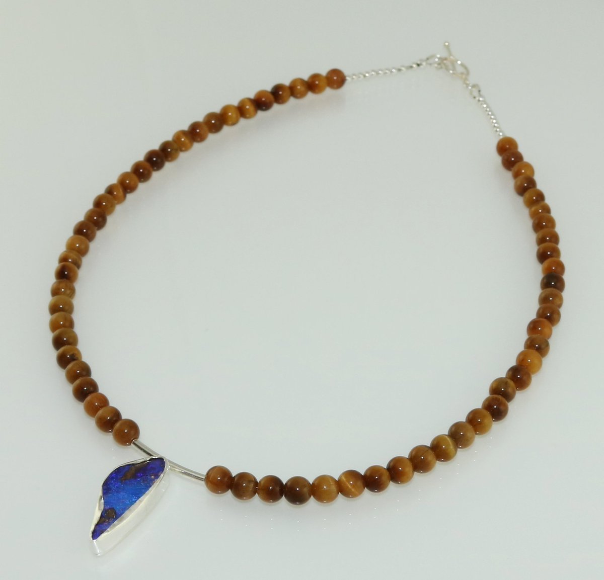 BookOfGems's tweet photo. Bezel set boulder opal with tiger eye &amp; sterling silver necklace https://t.co/CHeAWXRfBC #fashion #style #jewellery https://t.co/E3P0bGPayE