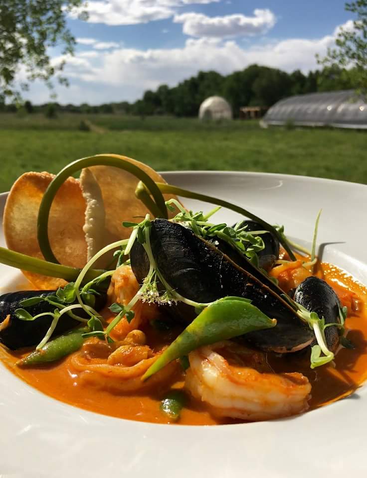PEI Mussels and shrimp in a New Mexico red chile curry broth with pickled scapes and a fried wonton.