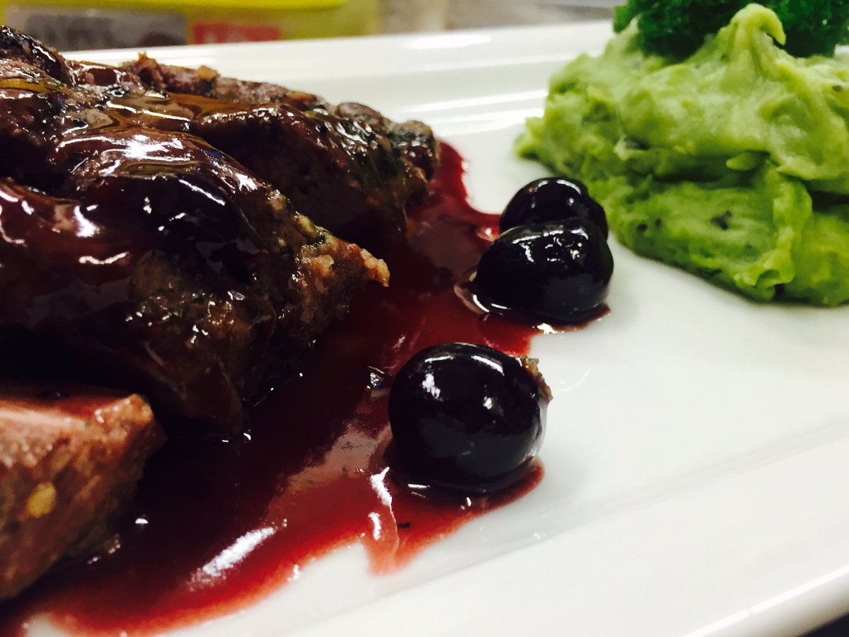 Lamb cutlets marinated in a light crumb with cherry red wine reduction and served with a minty pea mash