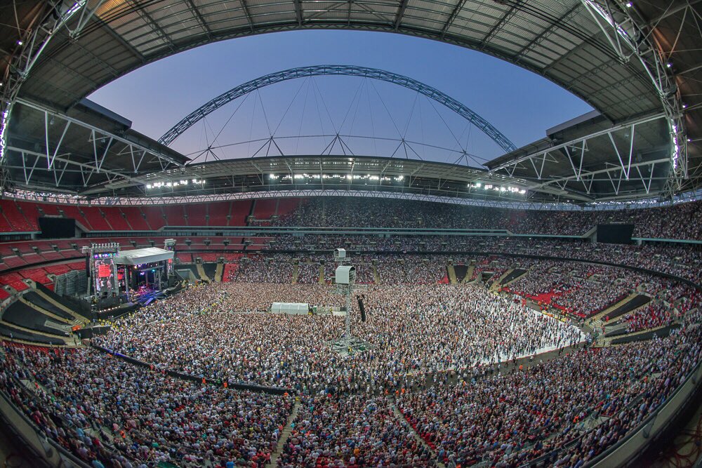 Wembley arena. Стадион Уэмбли БТС. Квин на стадионе Уэмбли. Футбольный стадион Уэмбли в Англии. Стадион Уэмбли в Лондоне вместимость.