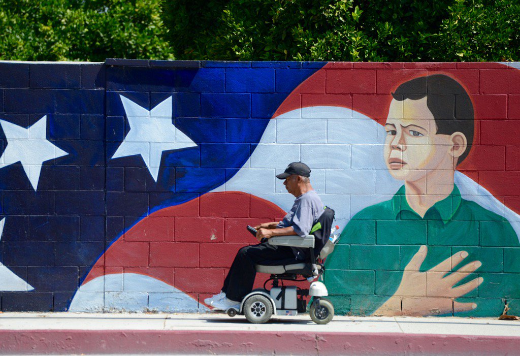 JCMaherPhoto's tweet photo. A man passes by a patriotic painting outside Philadelphia School in Pomona where residents are voting today. #IEVote https://t.co/f30v3NqIjD