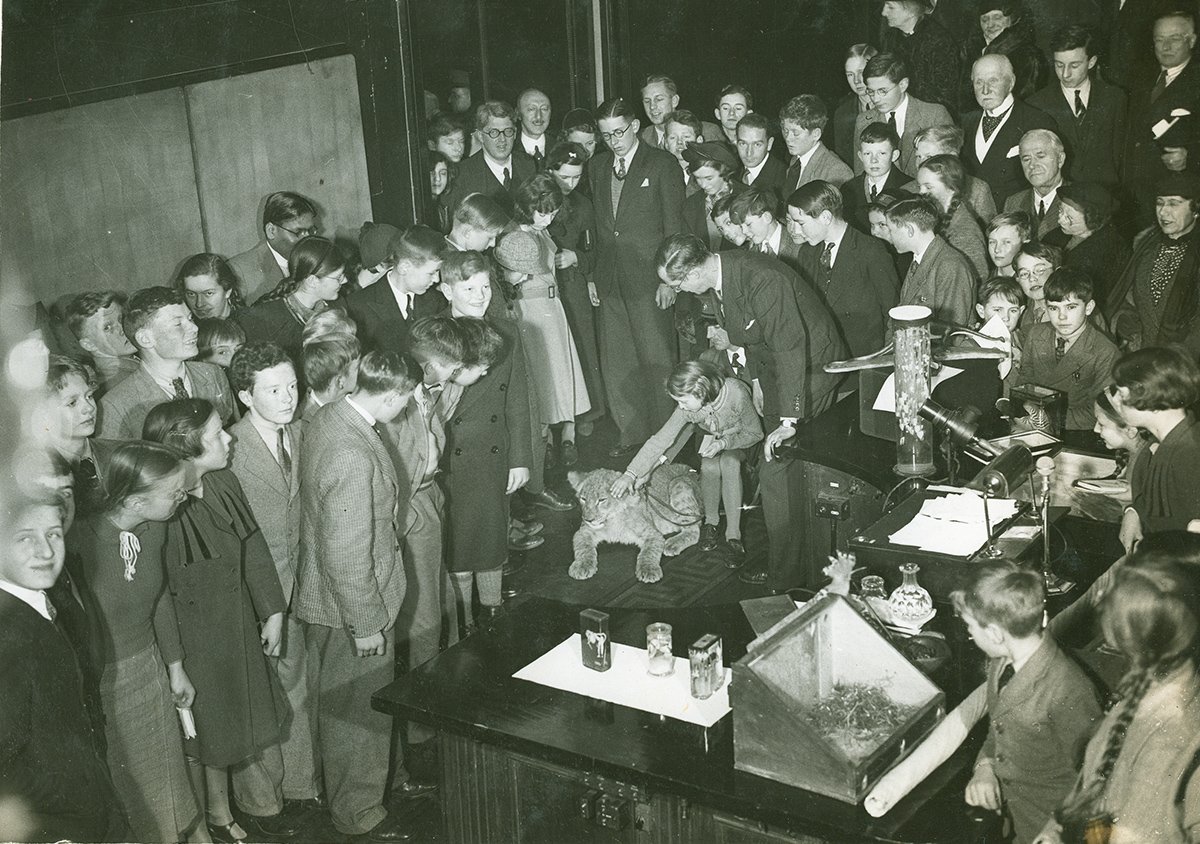 Biologist Julian Huxley was born #OnThisDay in 1887. Here, giving the 1937 #xmaslectures, with children and a lion