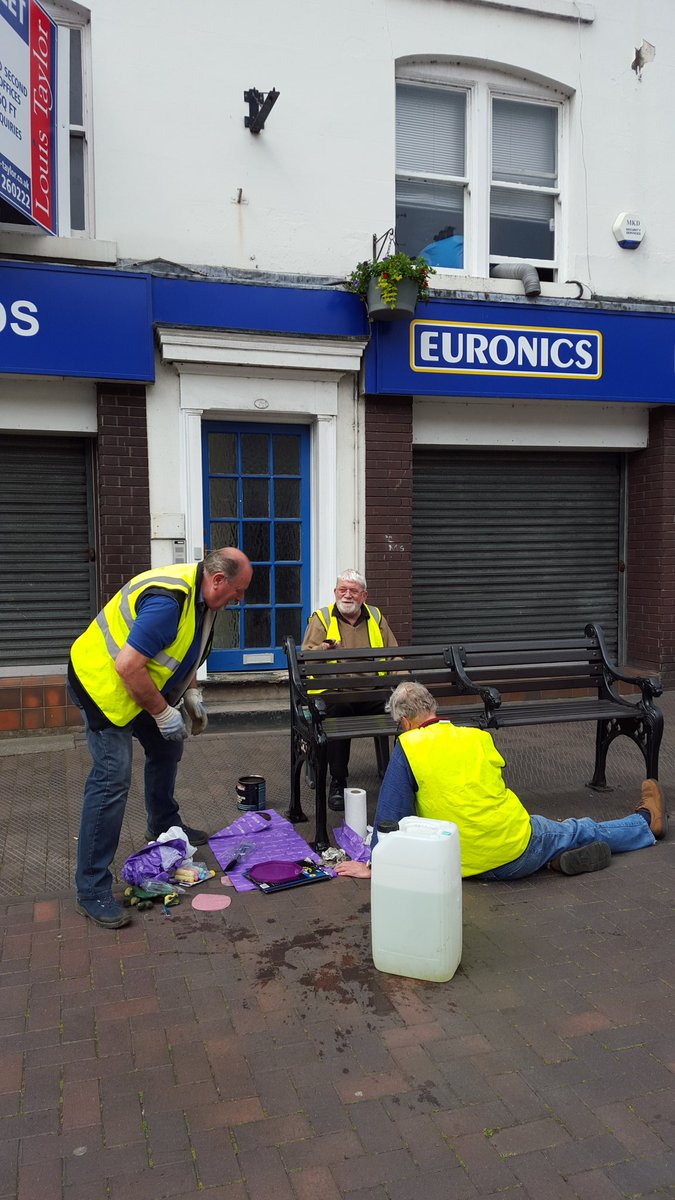 Stone in Bloom painting the Street furniture in the High Street busy people a tiny group of community volunteers