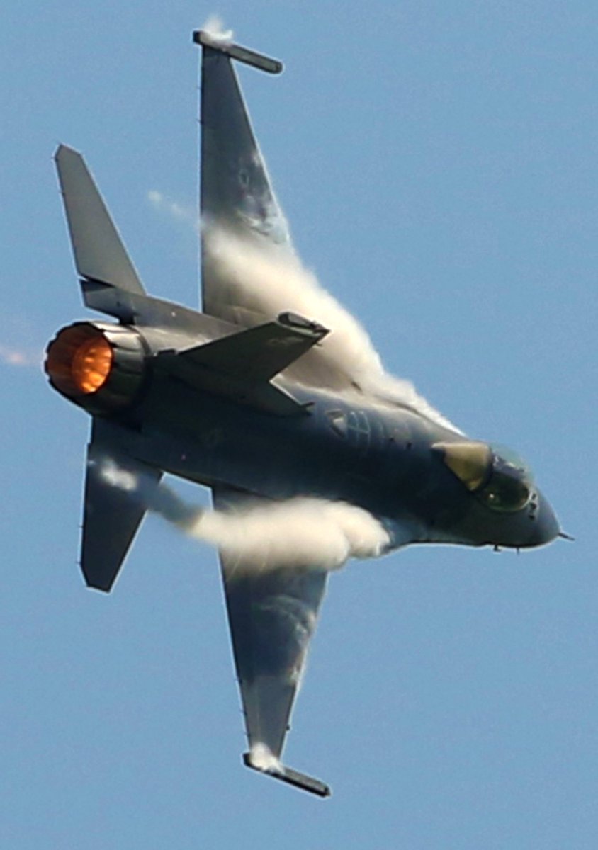 Vapor rolls off the wings of an F-16 Viper during a high speed turn on pactice day at the <a href="/QCAIRSHOW/">Quad City Air Show</a> .