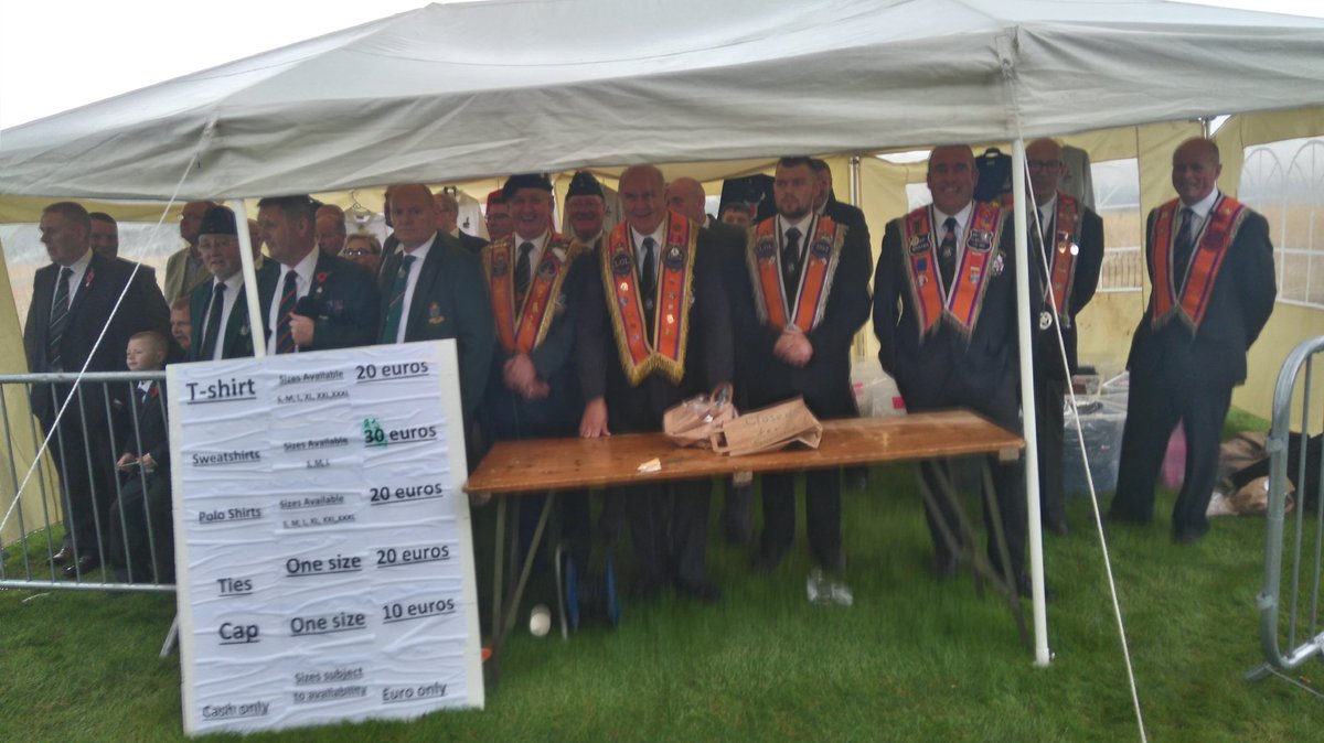 noeltupearly's tweet photo. Shelter from the storm. Orangemen under cover in the #Somme100 souvenir shop https://t.co/l546IizAHl