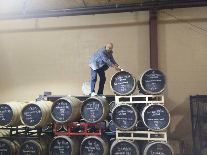 The owner of Napa Valley Distillery drawing some rum out of the casks for us to sample!
