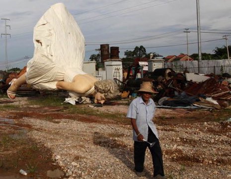 T2000000000's tweet photo. A man walks past a Marilyn Monroe statue at a garbage dump in the Guangxi Zhuang Autonomous Region, 2014 https://t.co/5mJSEK8ums