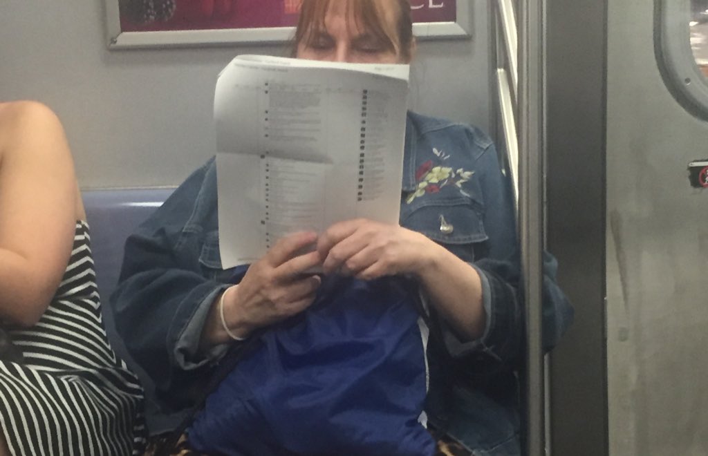 A woman on the subway printed out 15 pages of Facebook posts and is just reading the comments 🤔