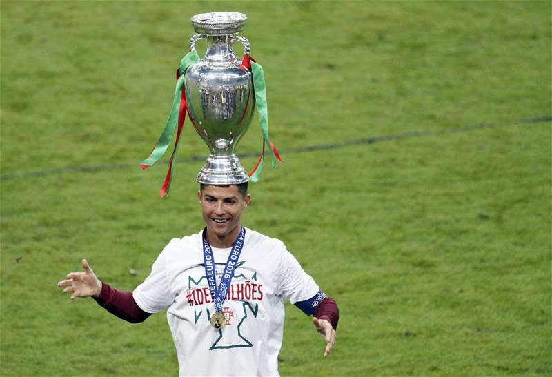 Cristiano Ronaldo with the European Championship trophy on his head. 