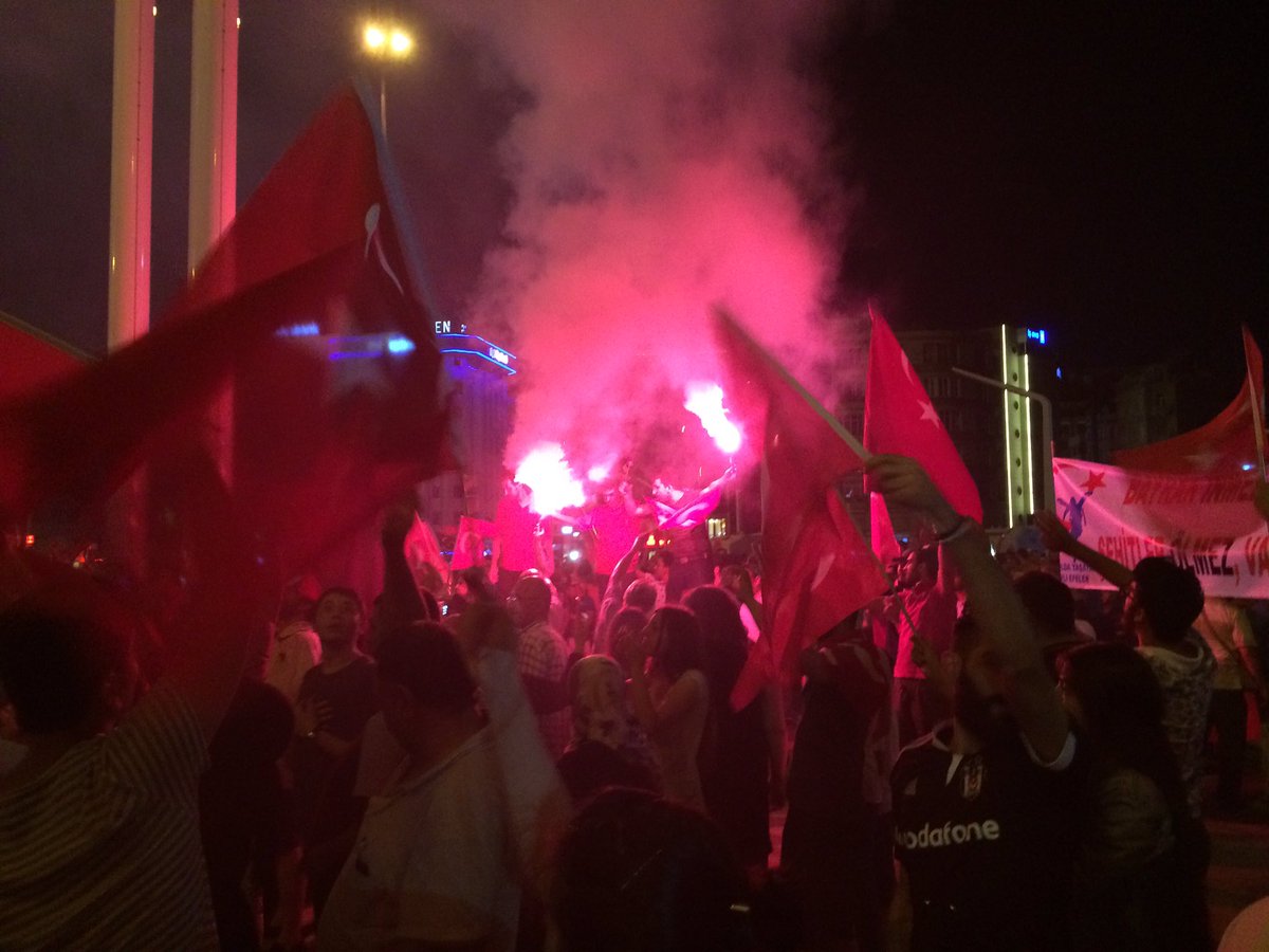 Bengaliska eldar kastar ett rött sken över Taksimtorget och det rödklädda firandet