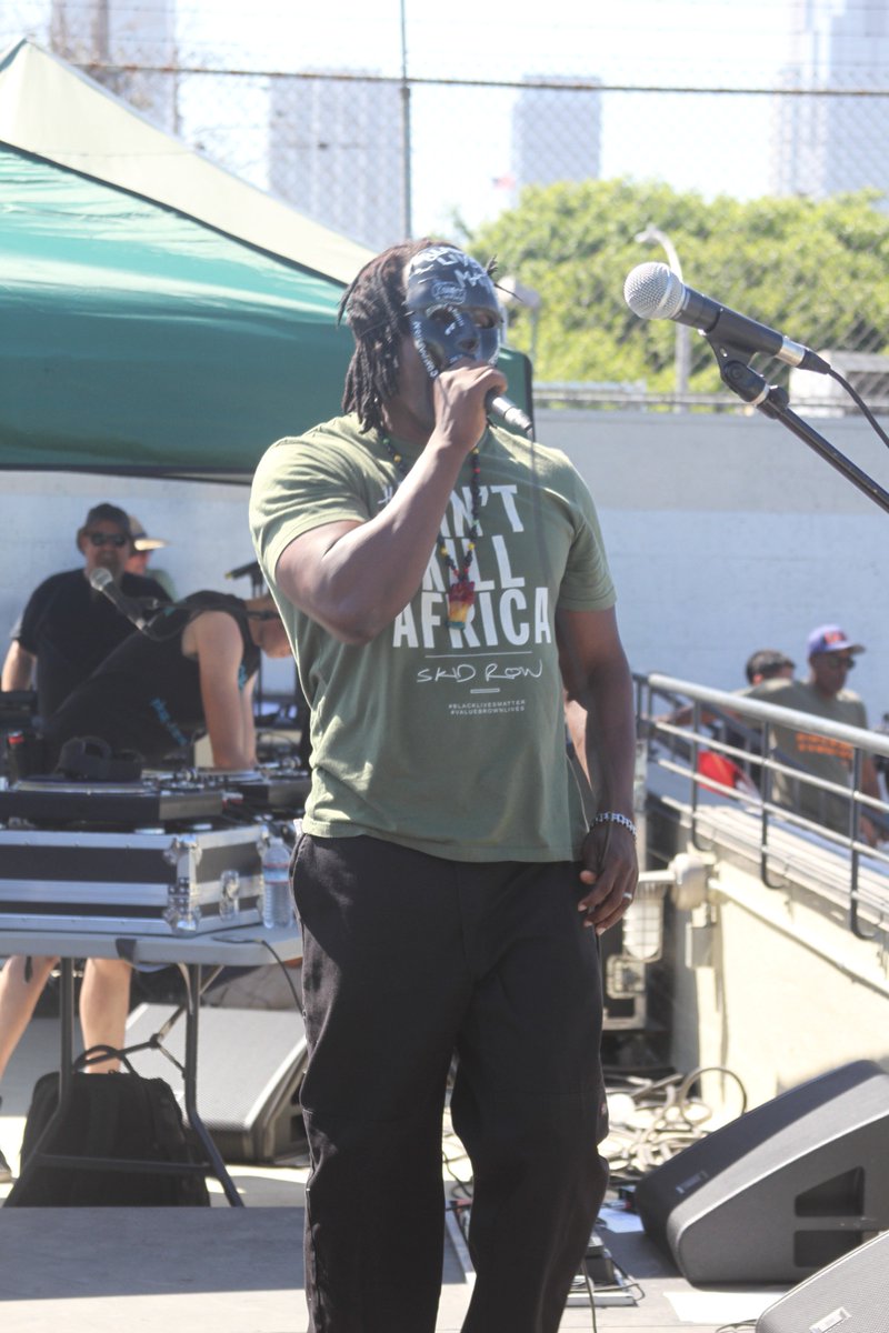 LACANetwork's tweet photo. Who is this masked revolutionary performing at #porskidrow? Bringing heat @CreatingJustice #ForgetRetirement https://t.co/OzWcP4IpkN
