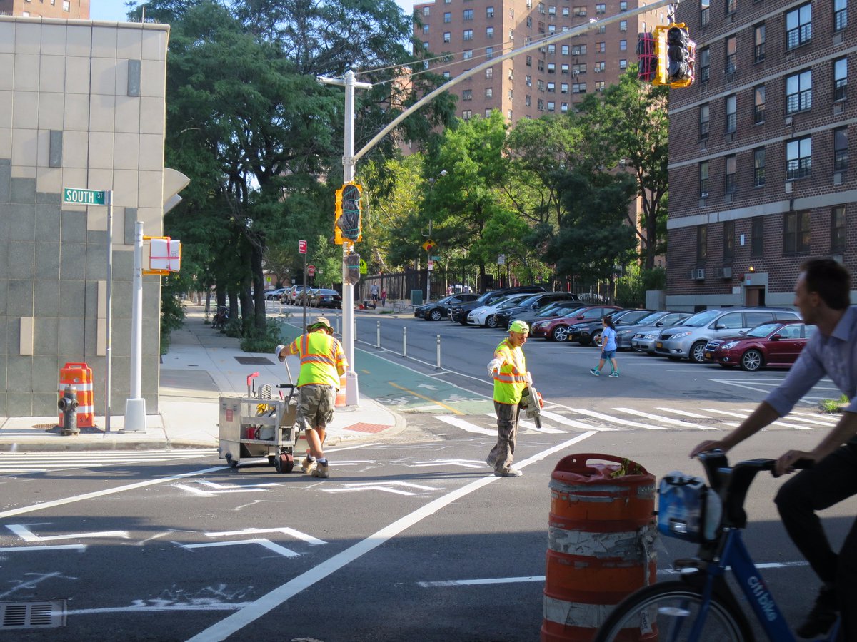 NYC_DOT's tweet photo. Markings crew installs thermoplastic path across #SouthSt to protected #bikenyc lane on #ClintonSt. #LES #VisionZero https://t.co/bn3kidb7F8