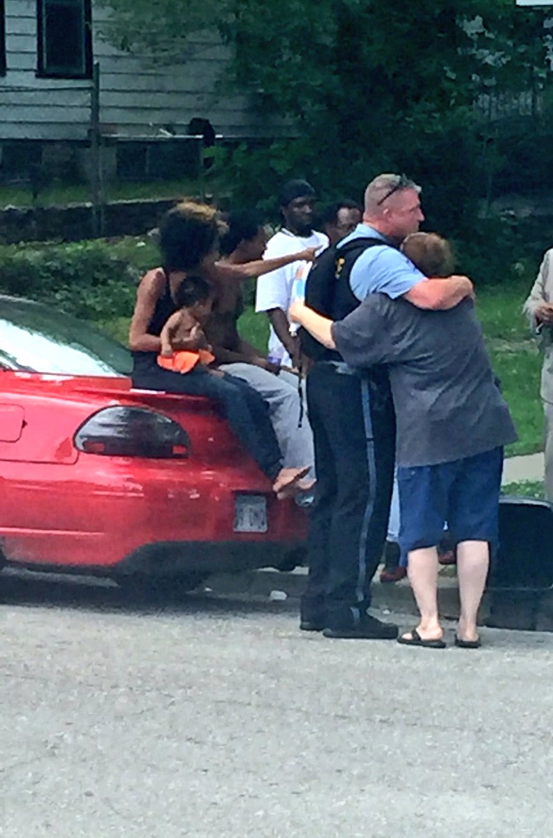 LexiSutterTV's tweet photo. Officer hugging neighbor near scene where Capt. Melton died 
#prayforpeace #prayforKCK @41ActionNews https://t.co/czq4YA7TGn