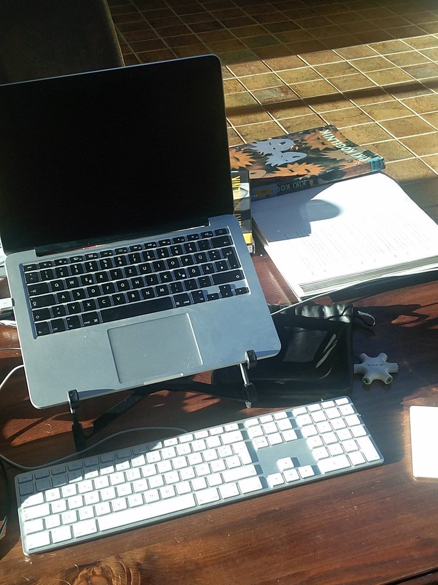 MacBook Pro on roost stand with Apple keyboard and external trackpad