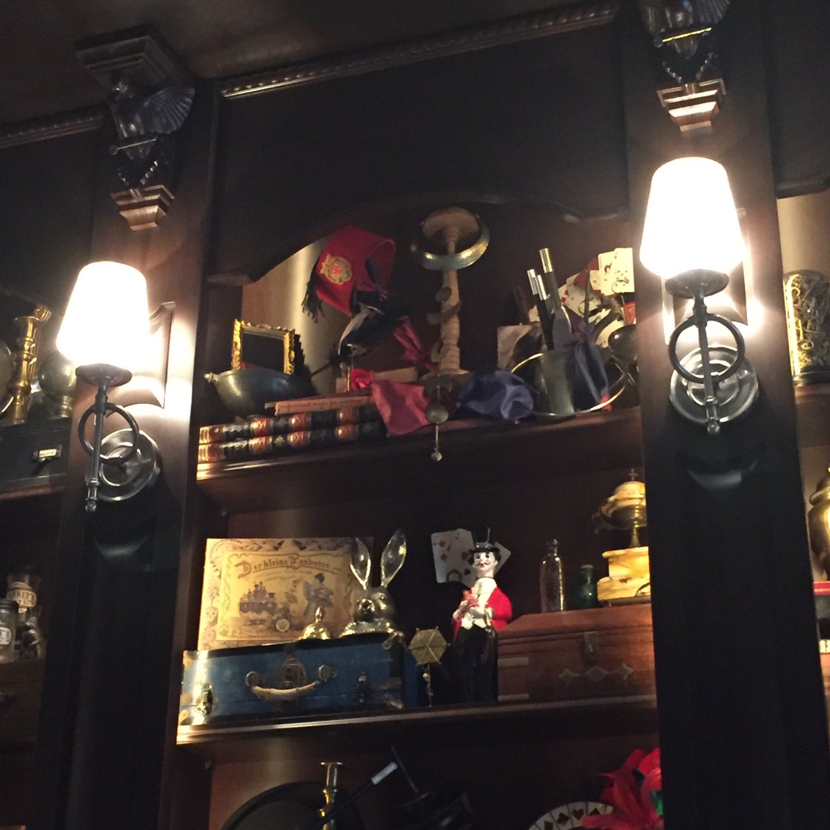 WDWNT's tweet photo. There's a S.E.A. Fez on the top shelf of the display shelf in AbracadaBar https://t.co/80Wg8XgGkk