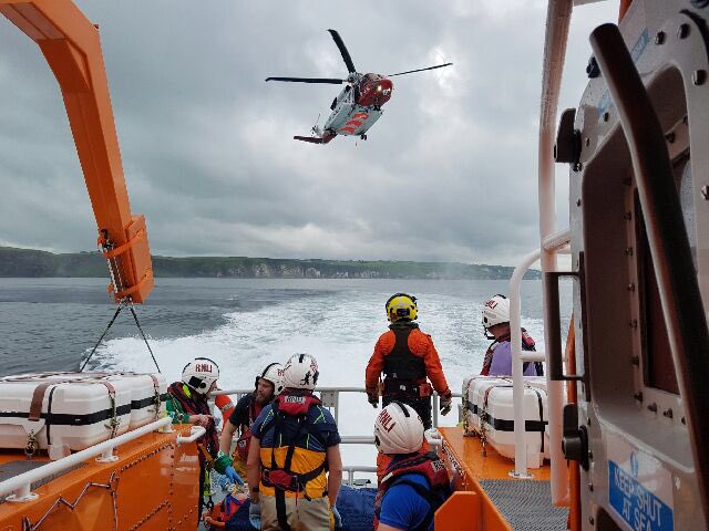 PortrushRNLI's tweet photo. Volunteer crews back at station.Assisted with transfer of casualty from Dunluce to helicopter #classictraining https://t.co/3NLjAe9LPZ
