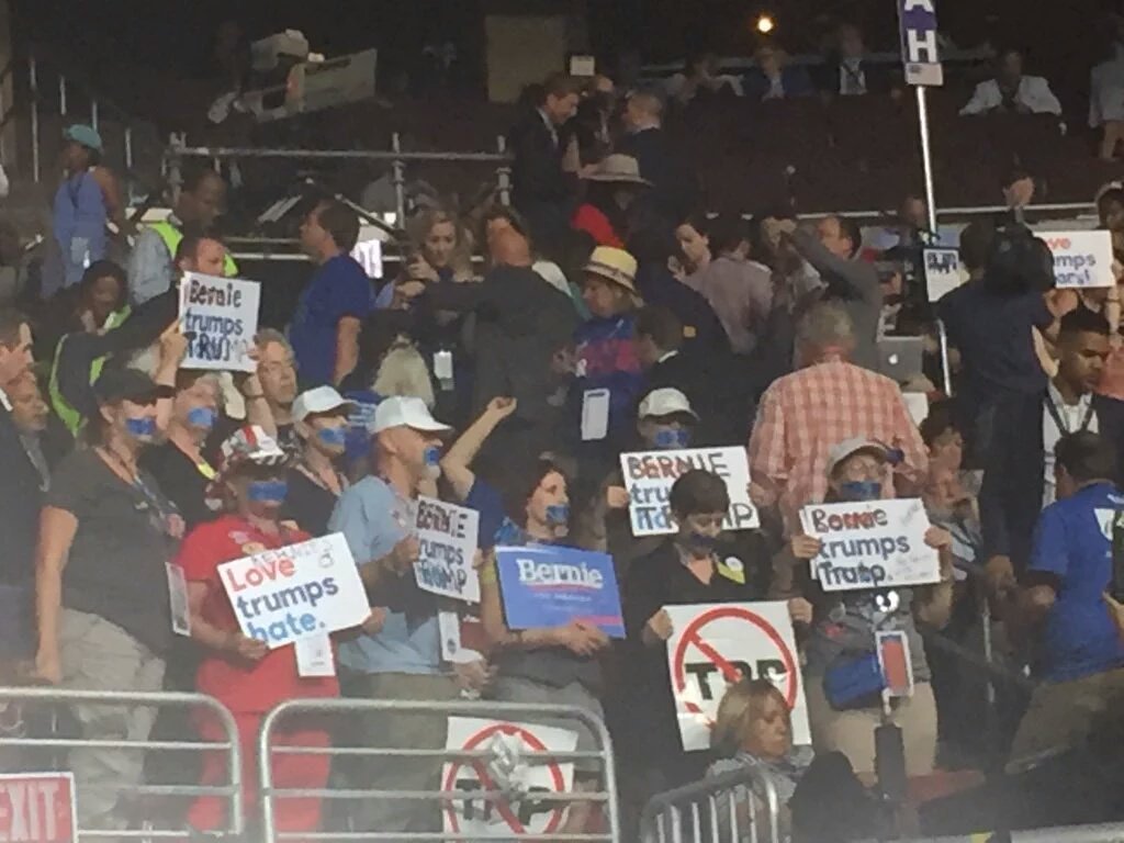 BiologistDan's tweet photo. #Michigan delegates were told to be quiet so they're standing with tape over their mouths #DemsInPhilly #DNCinPHL https://t.co/xSKaScXsFK